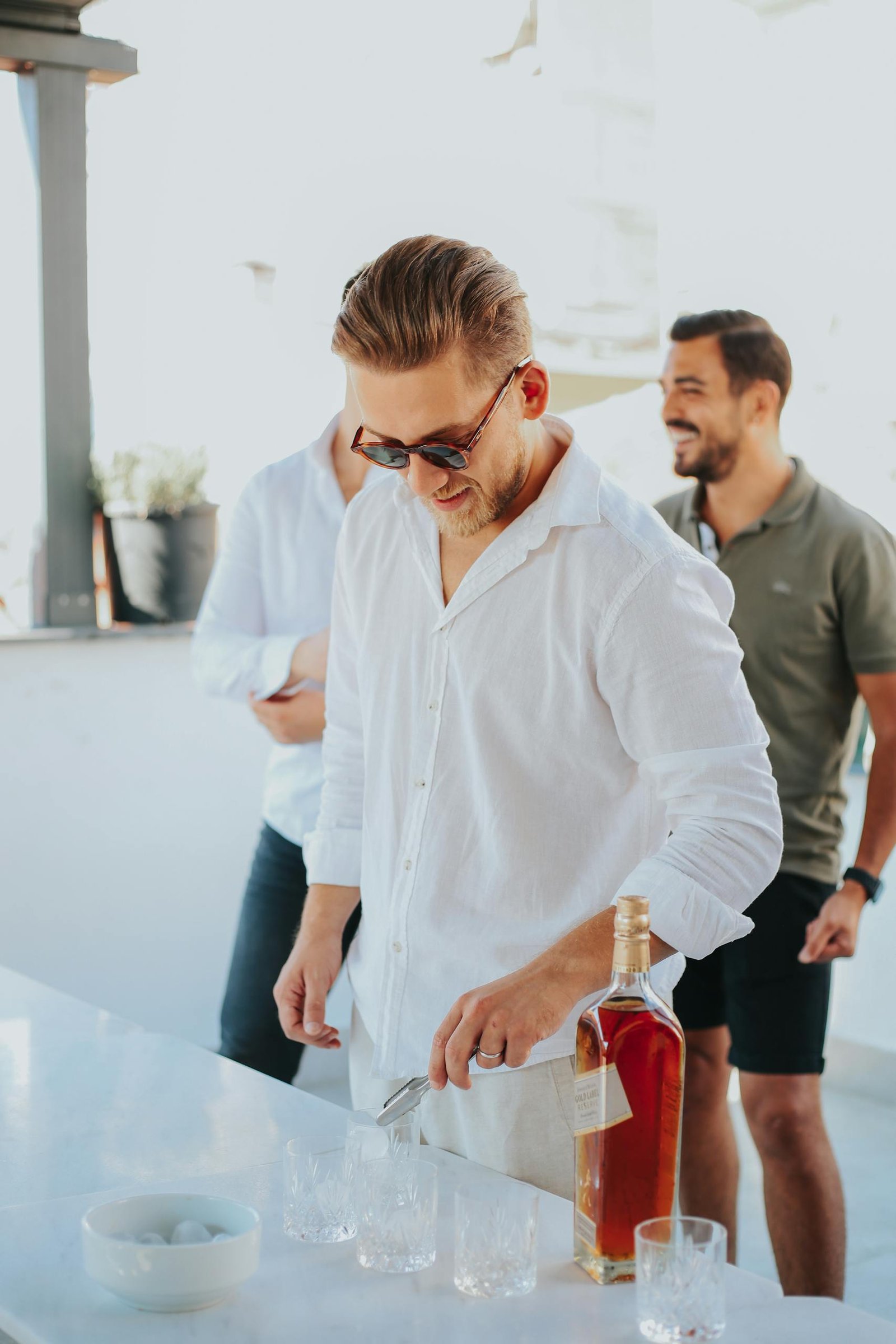 Group of friends enjoying drinks outdoors with smiles and leisure vibes.